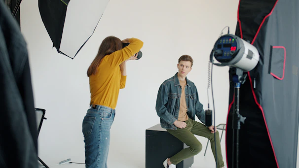 Photographer directs model during studio photoshoot session.