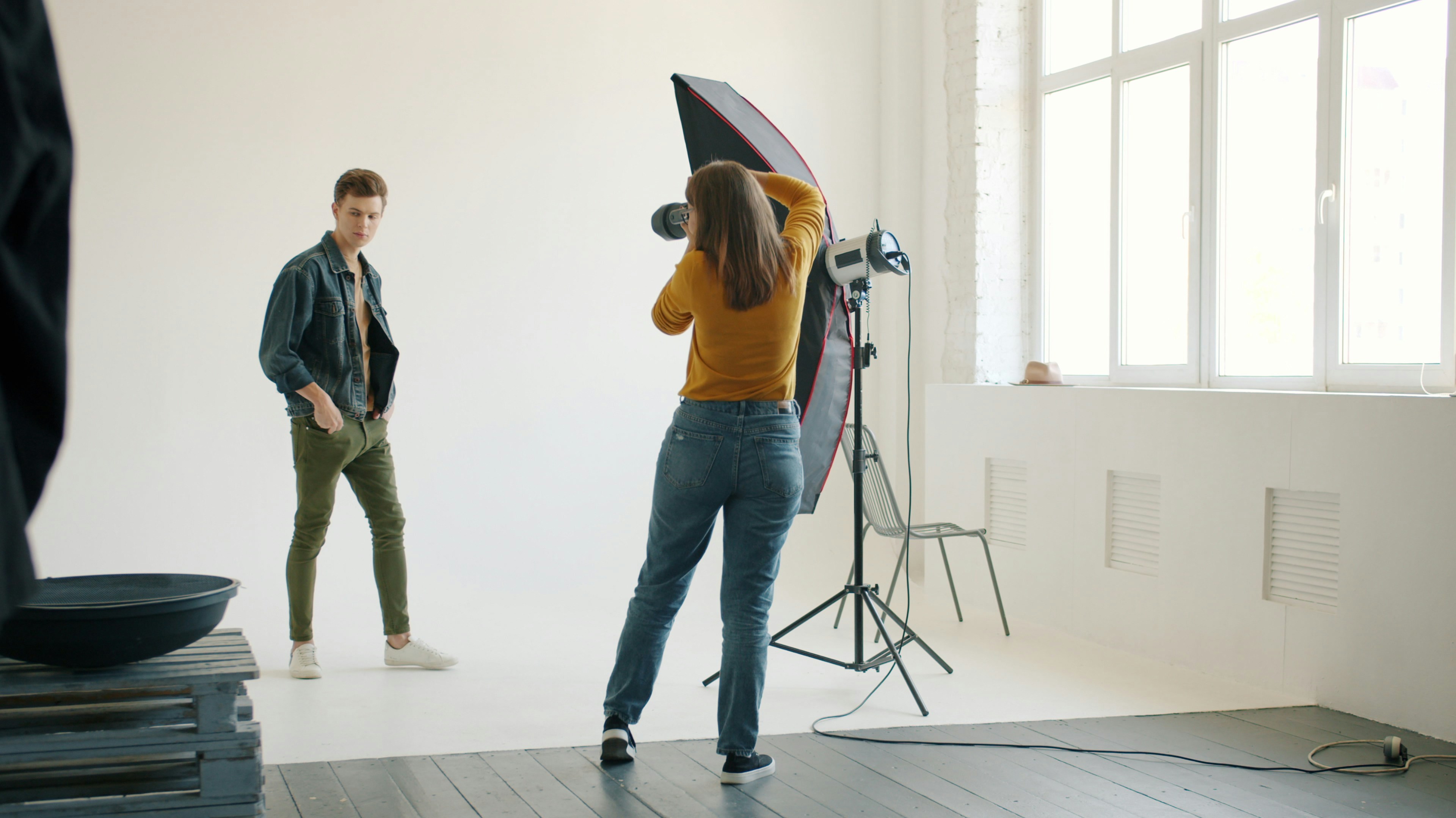 Photographer positioning a male model under studio lights