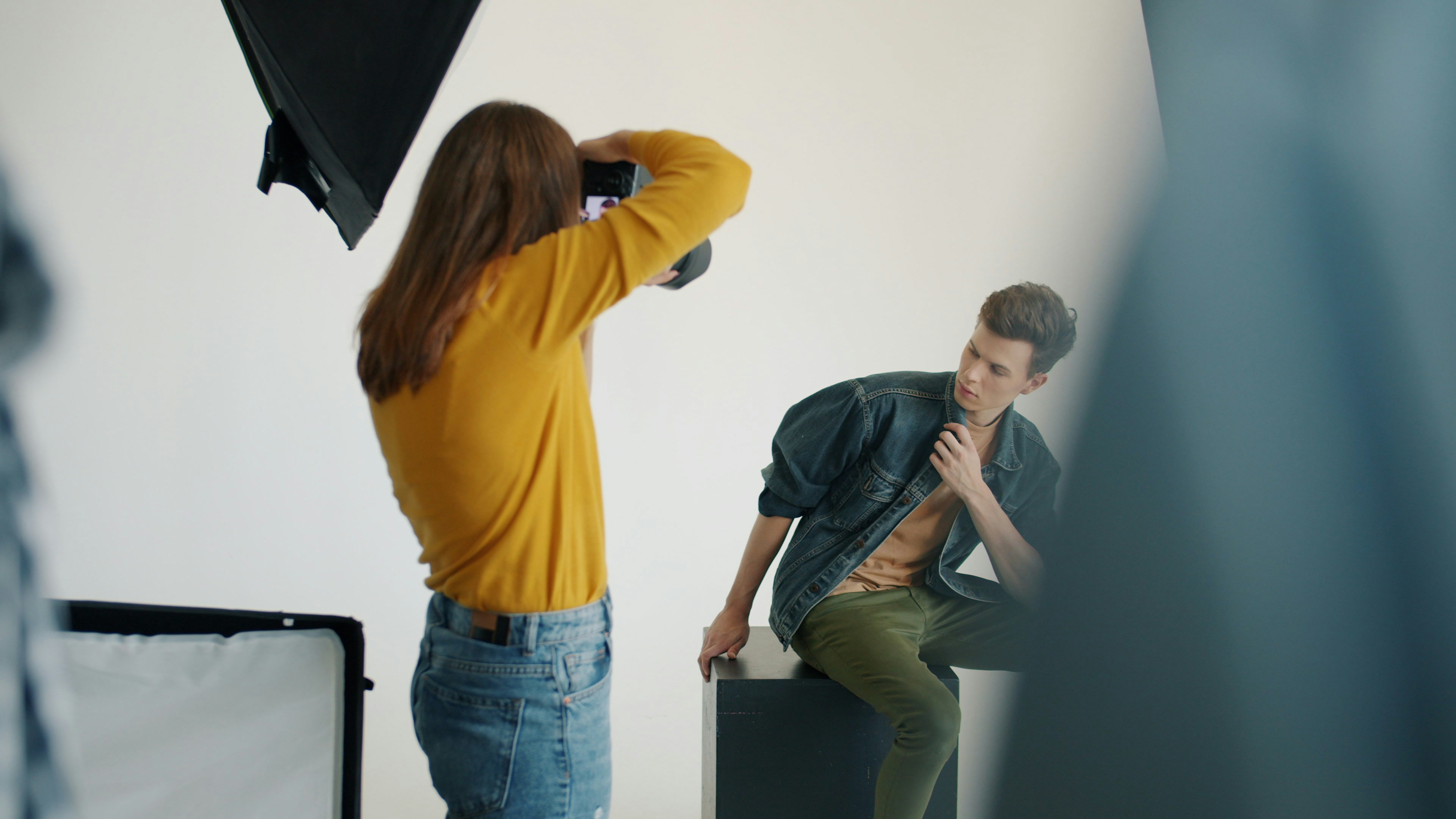 Photographer taking picture of male model in studio.