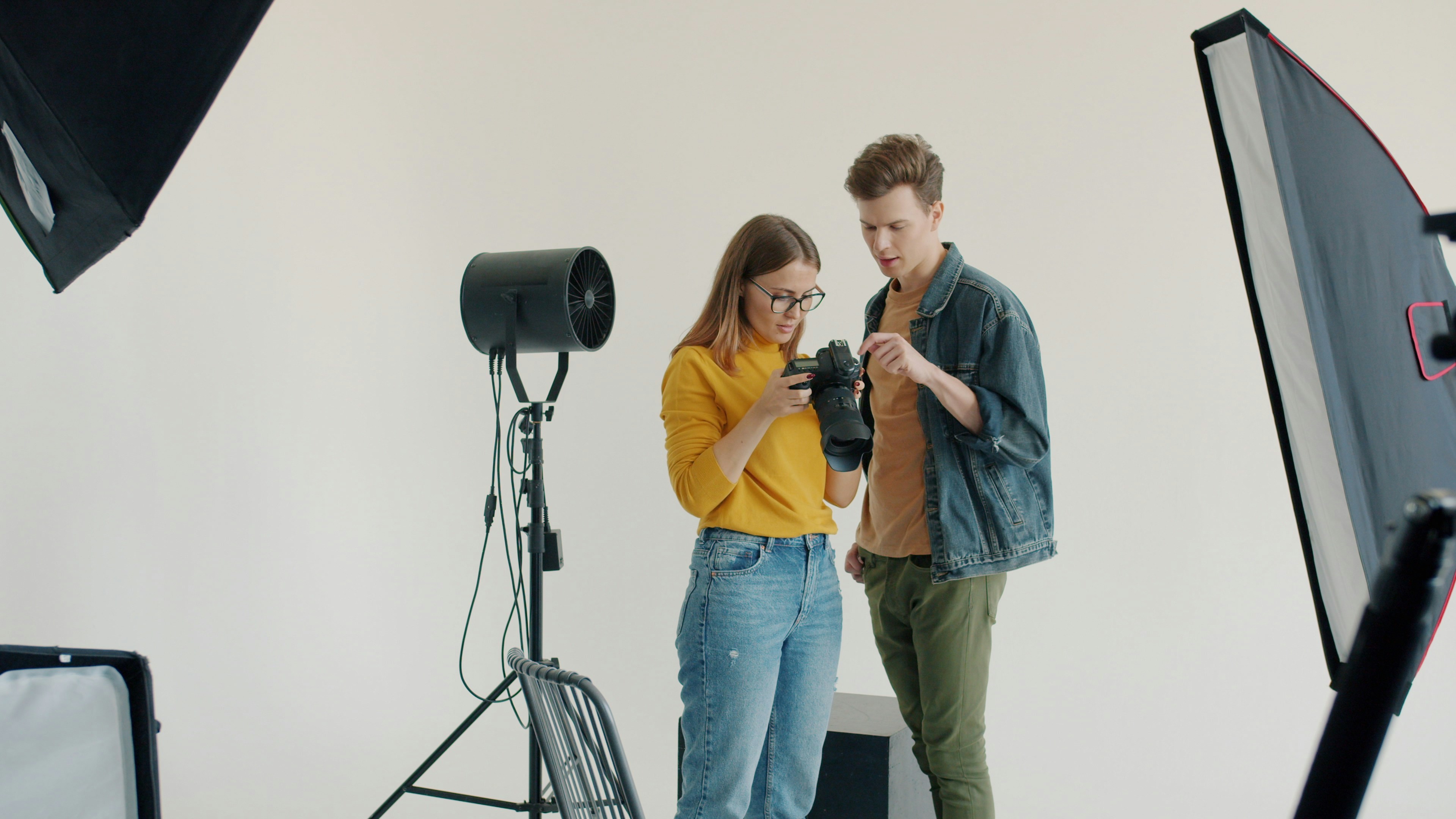 Two people examining a camera in a studio