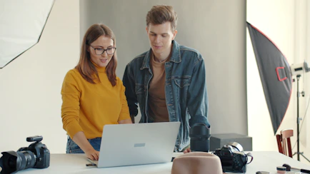 Two people looking at a laptop in a studio