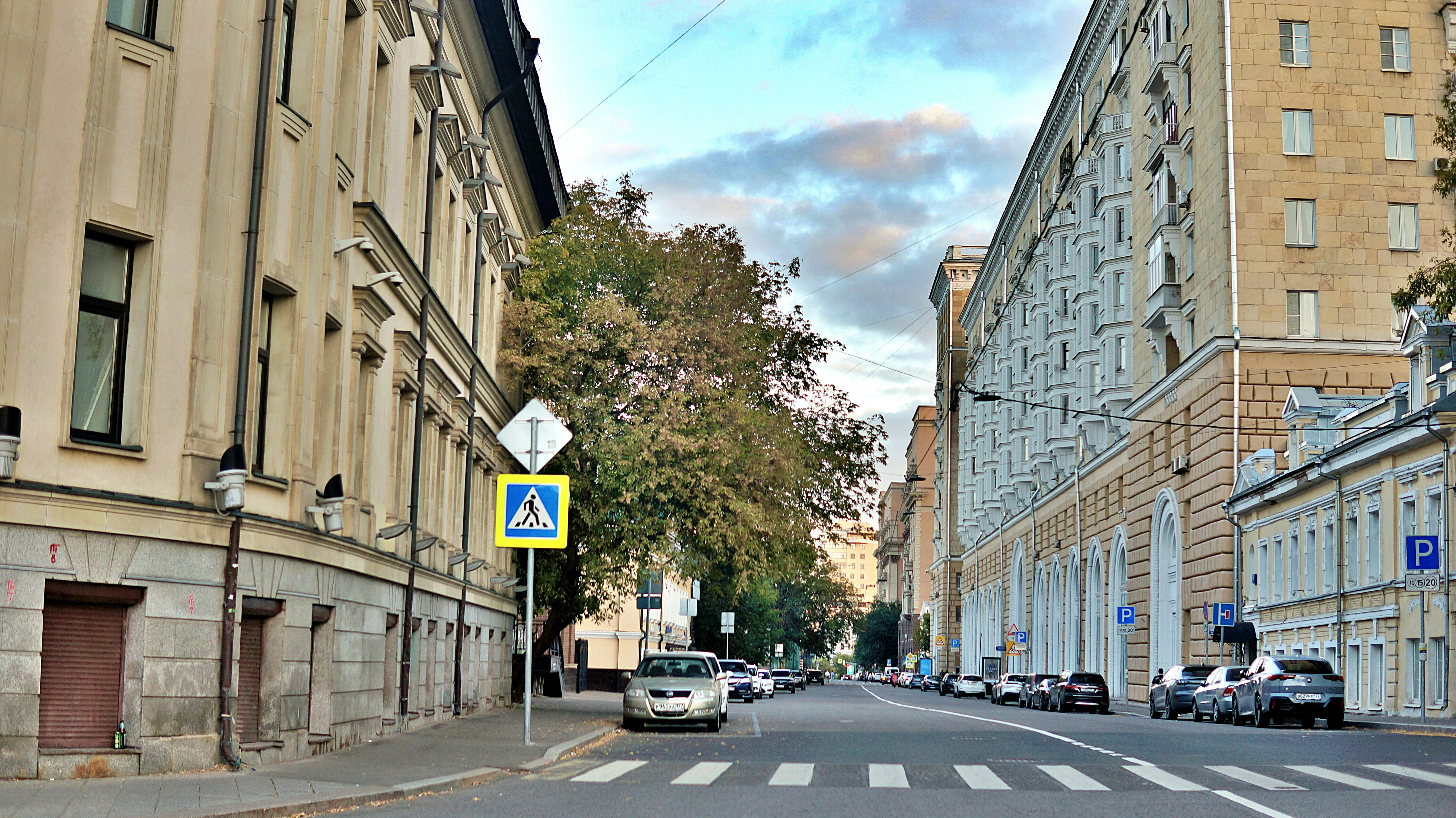 Street scene with buildings and cars on a cloudy day