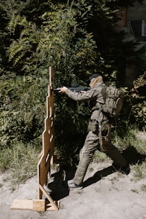 Soldier aiming rifle at target practice outdoors