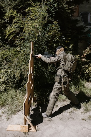 Soldier aiming rifle at target practice outdoors