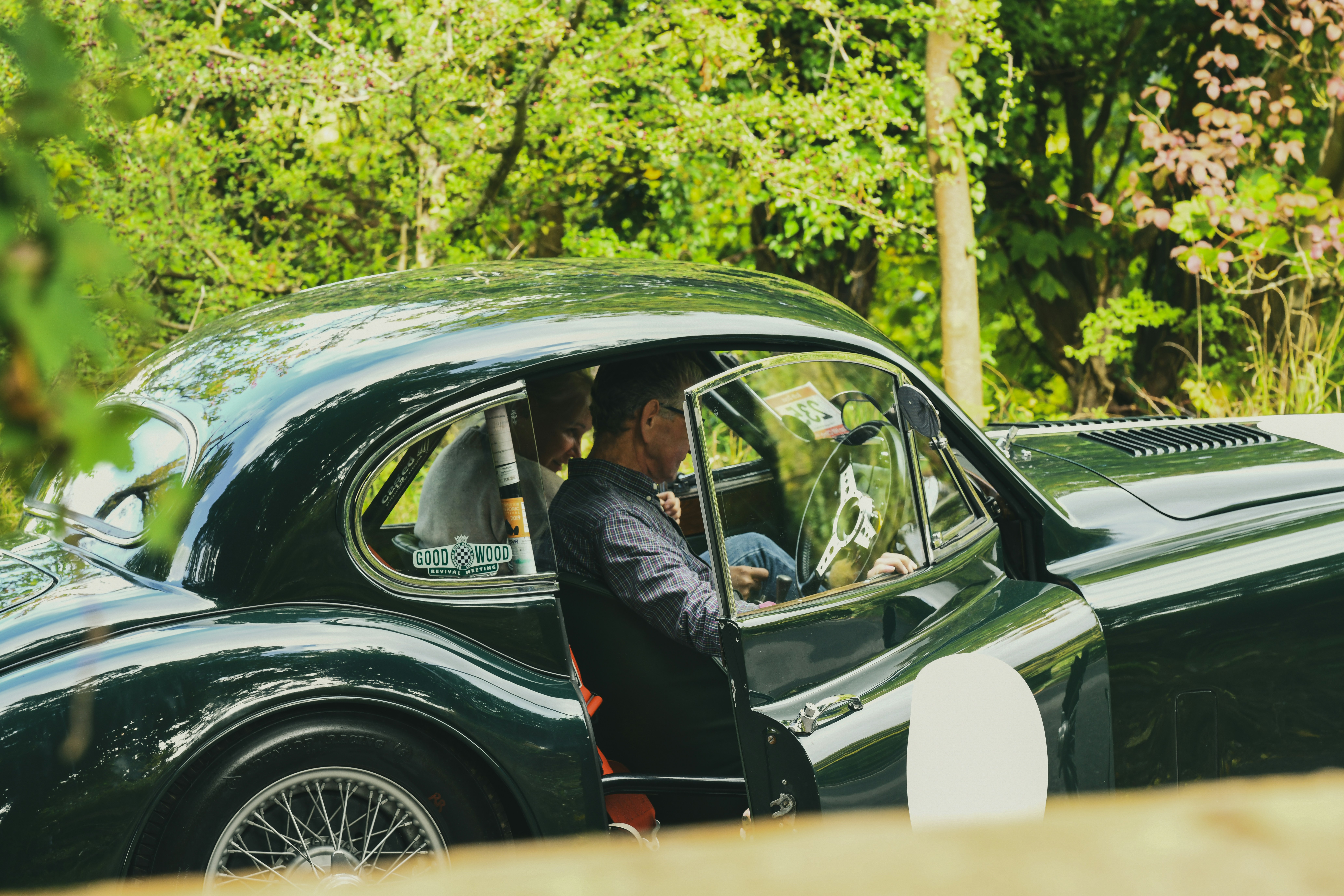 Man standing by a vintage green car