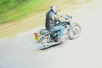 Motorcyclist riding on a road with motion blur.