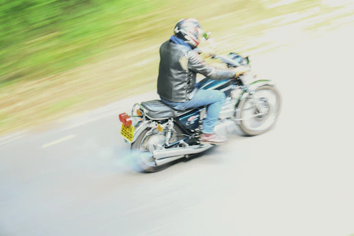 Motorcyclist riding on a road with motion blur.