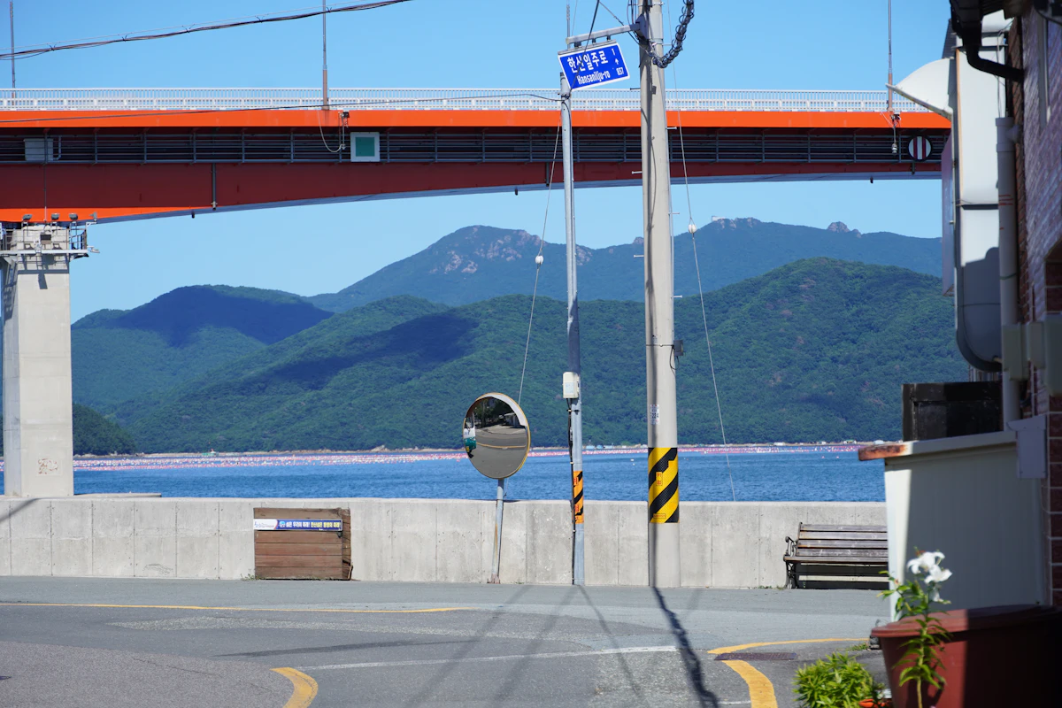 Quiet Korean coastal town with a bridge over calm water and hills behind