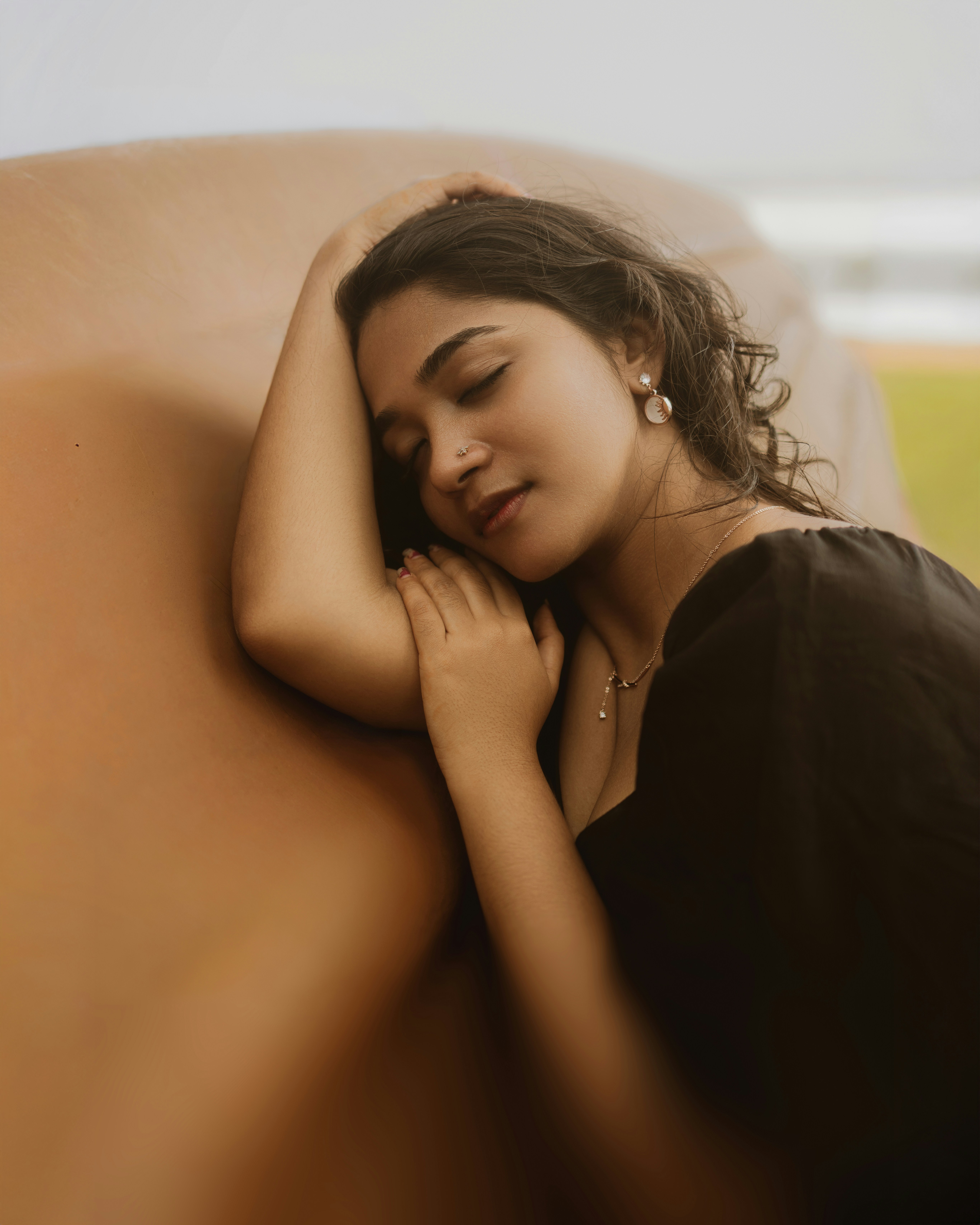 A young woman rests her head on her arm.