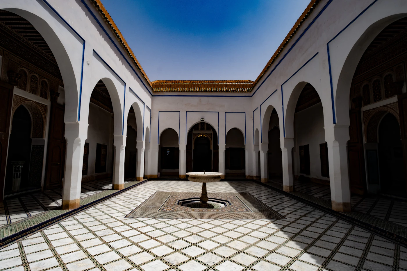 Patio central du Riad Zahrat Al Sahara — fontaine en zellige et arcades, lumière sablonneuse de la médina de Marrakech