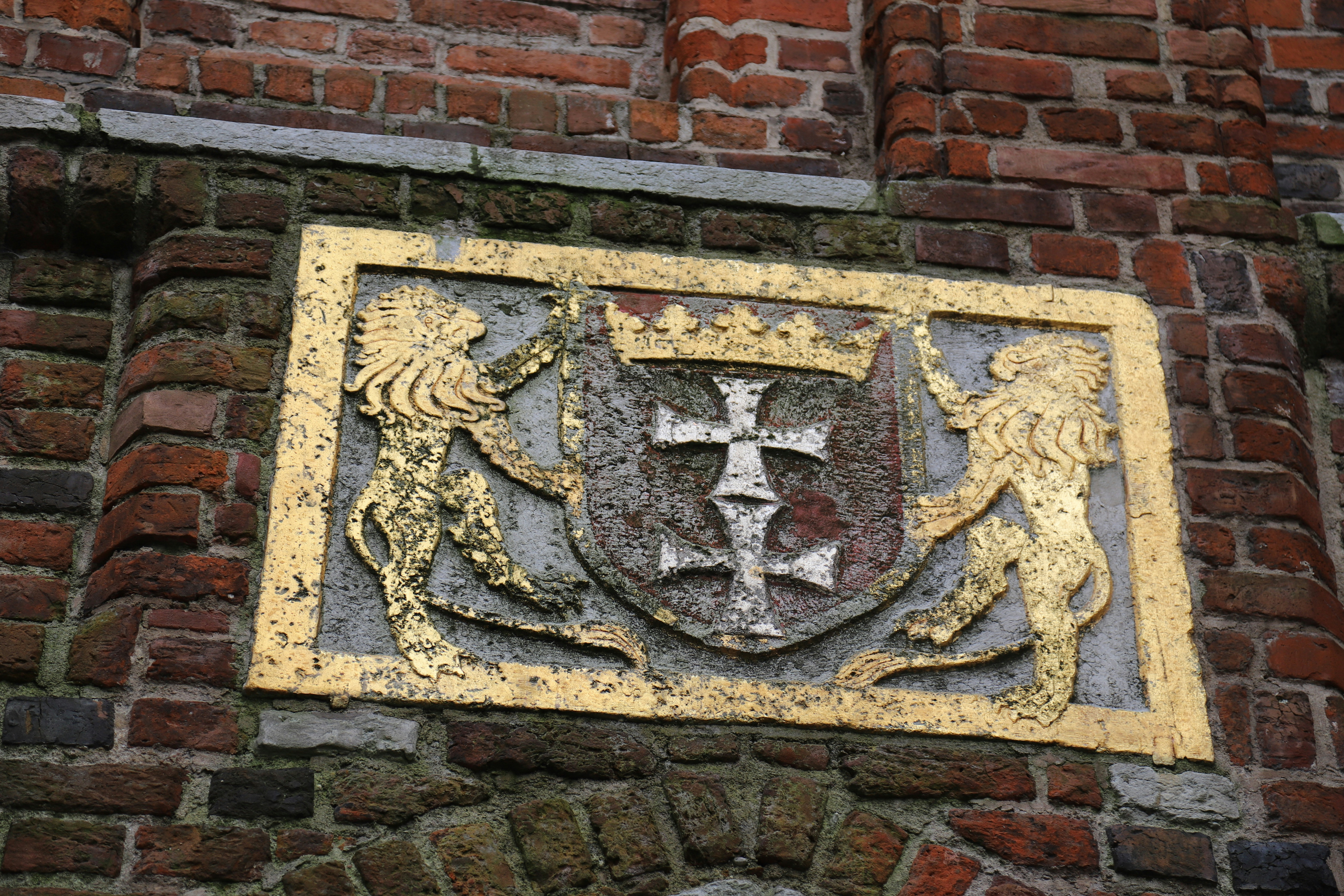 Coat of arms with lions on brick wall