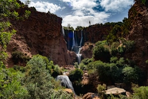 Majestic waterfalls cascade down rocky cliffs surrounded by lush greenery.