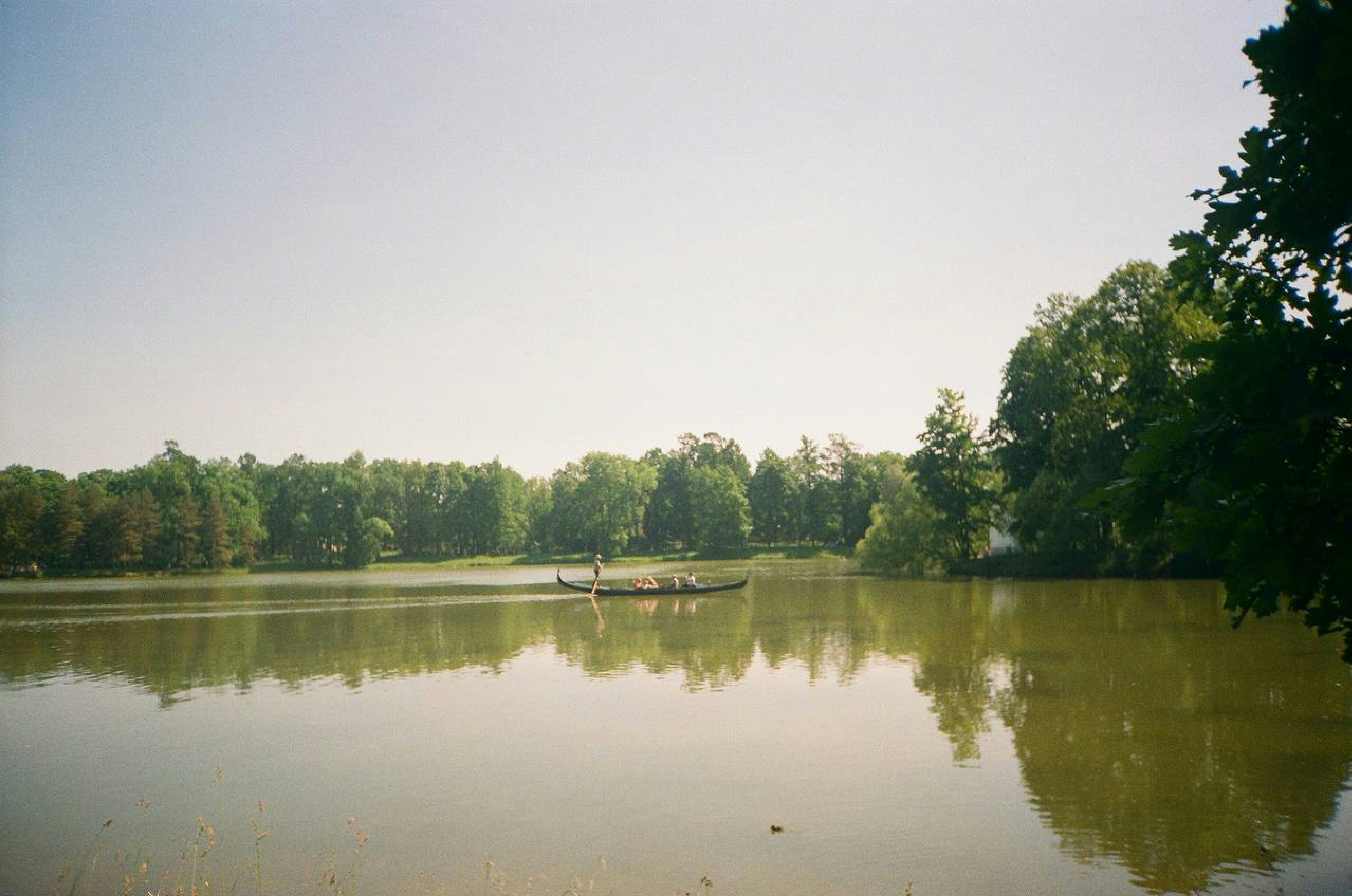 People on boat on calm lake with trees