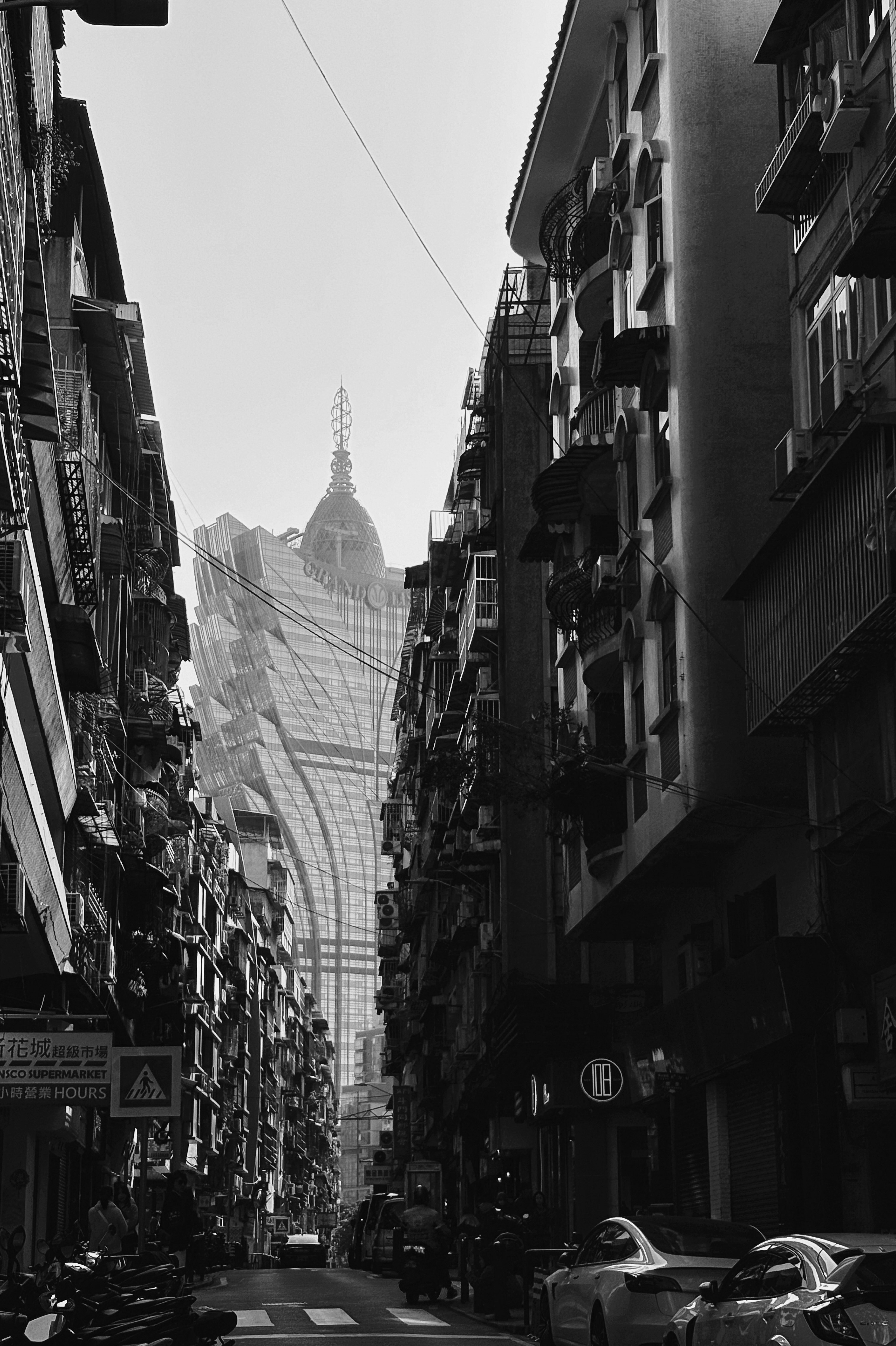 Narrow street between buildings with skyscraper in distance