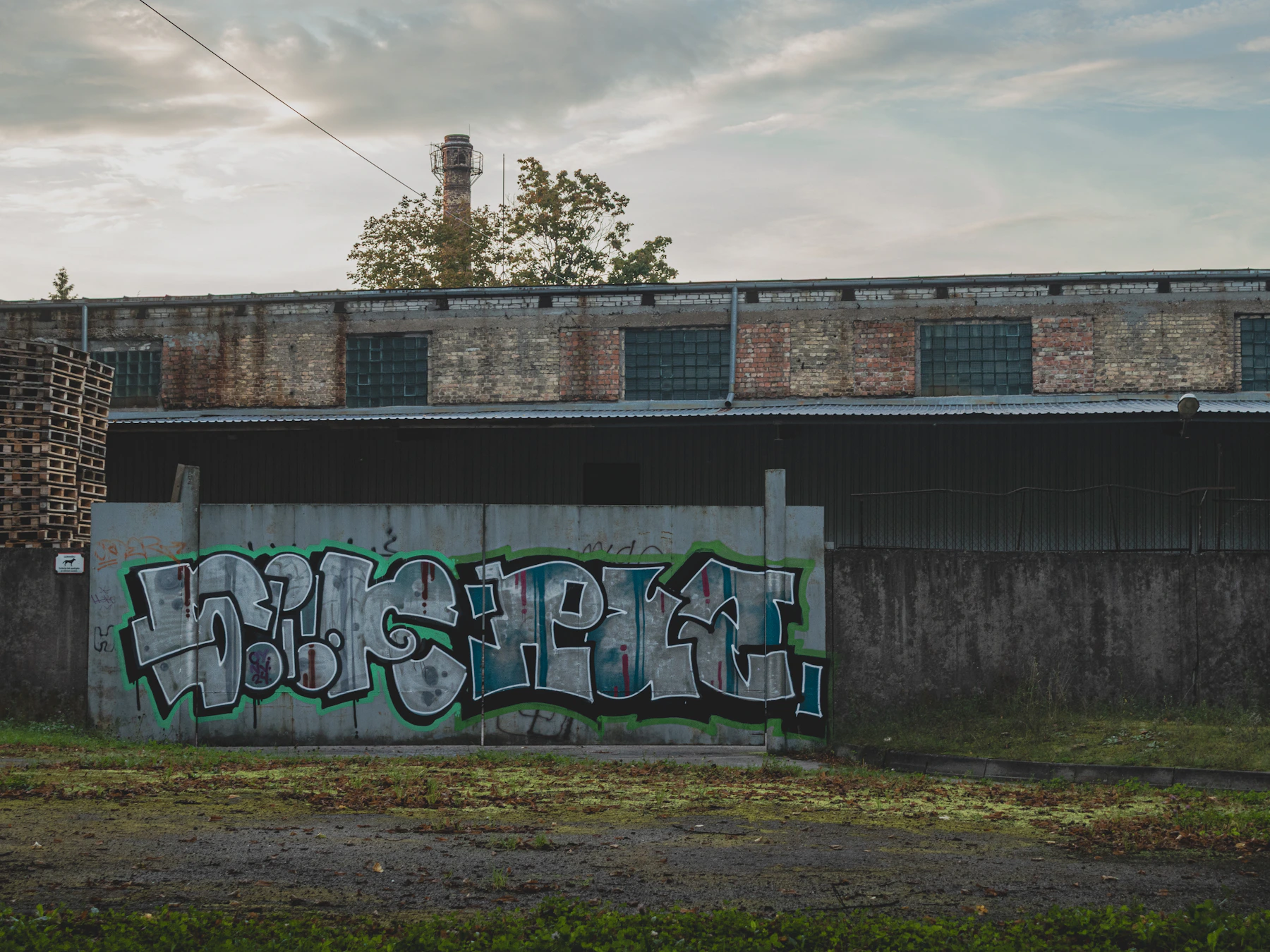 Graffiti sur une grande surface de béton dans un contexte industriel
