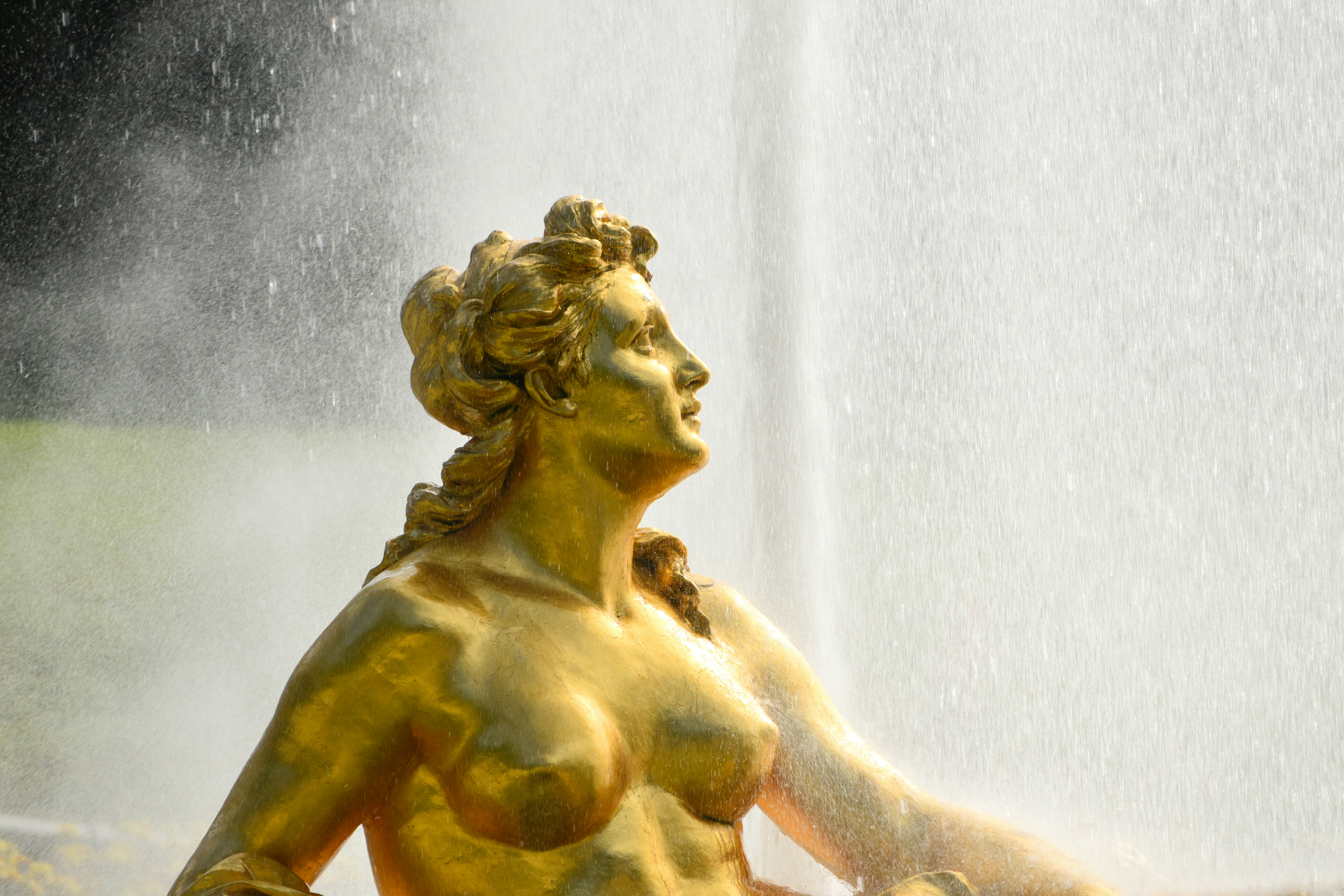 Golden statue of a woman with water spray