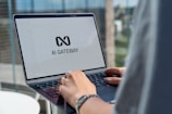 Person typing on laptop with ai gateway logo.