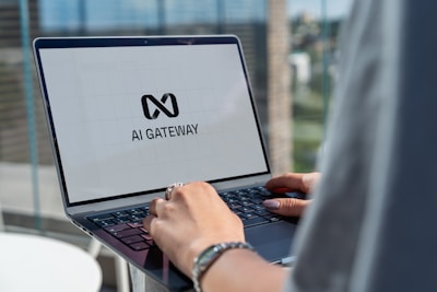Person typing on laptop with ai gateway logo.