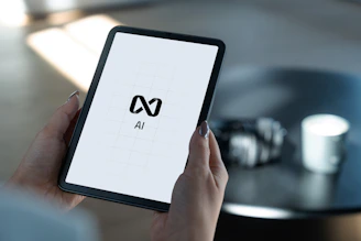 Hands holding a tablet displaying ai logo