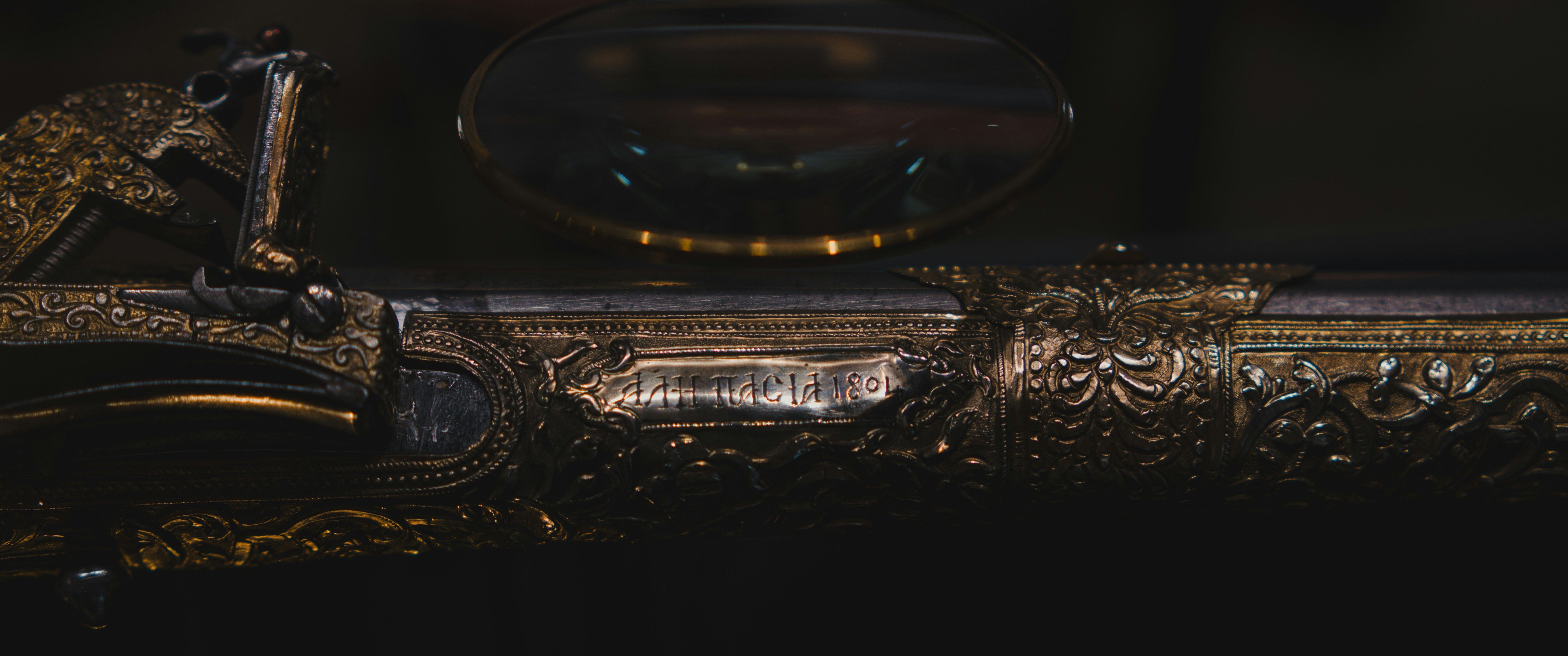 A craftsman carefully inspecting an engraved metal tag.