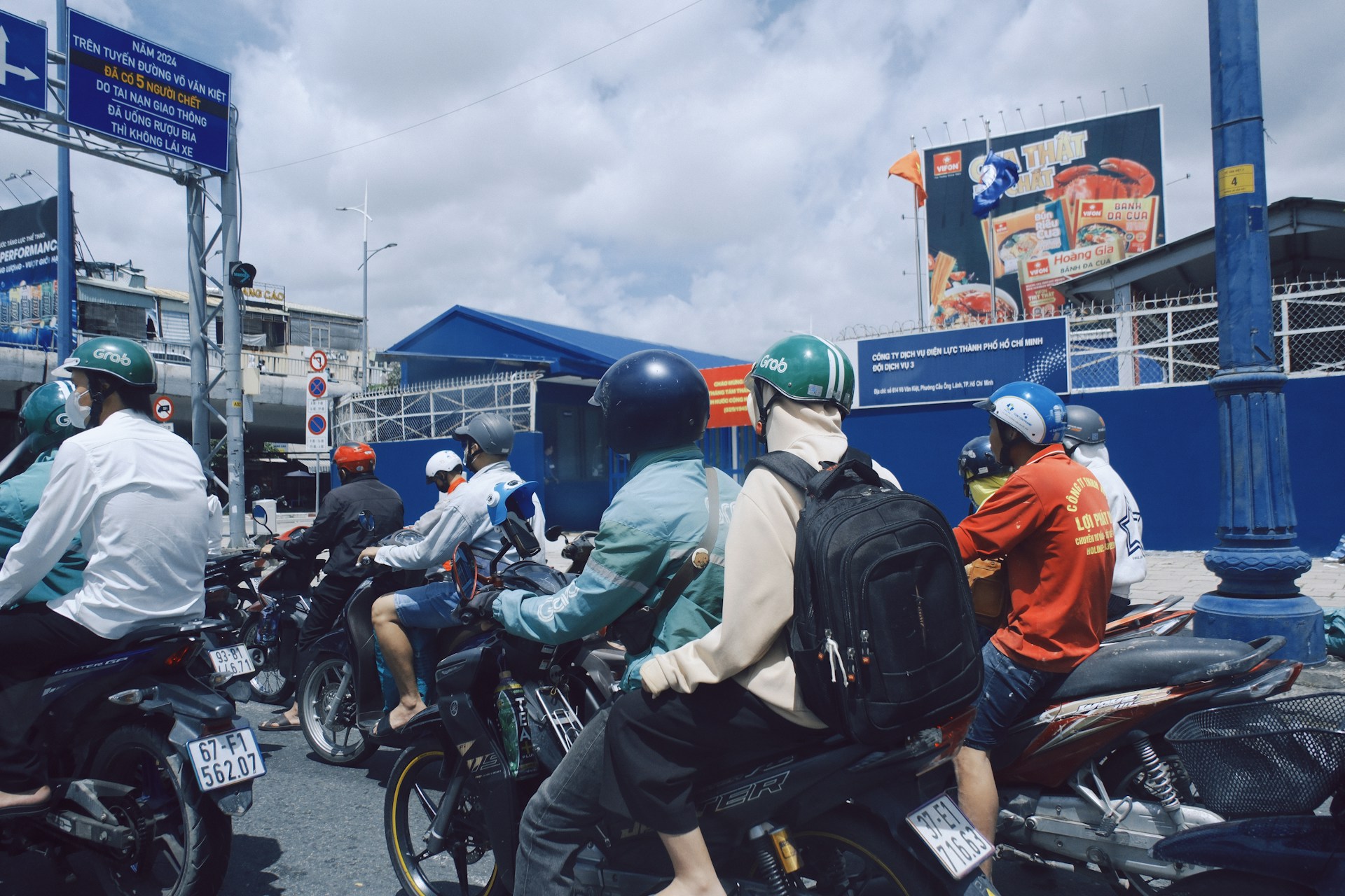 Motorcyclists waiting at a busy intersection