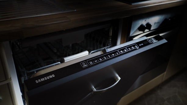 A modern samsung dishwasher drawer built into cabinetry.