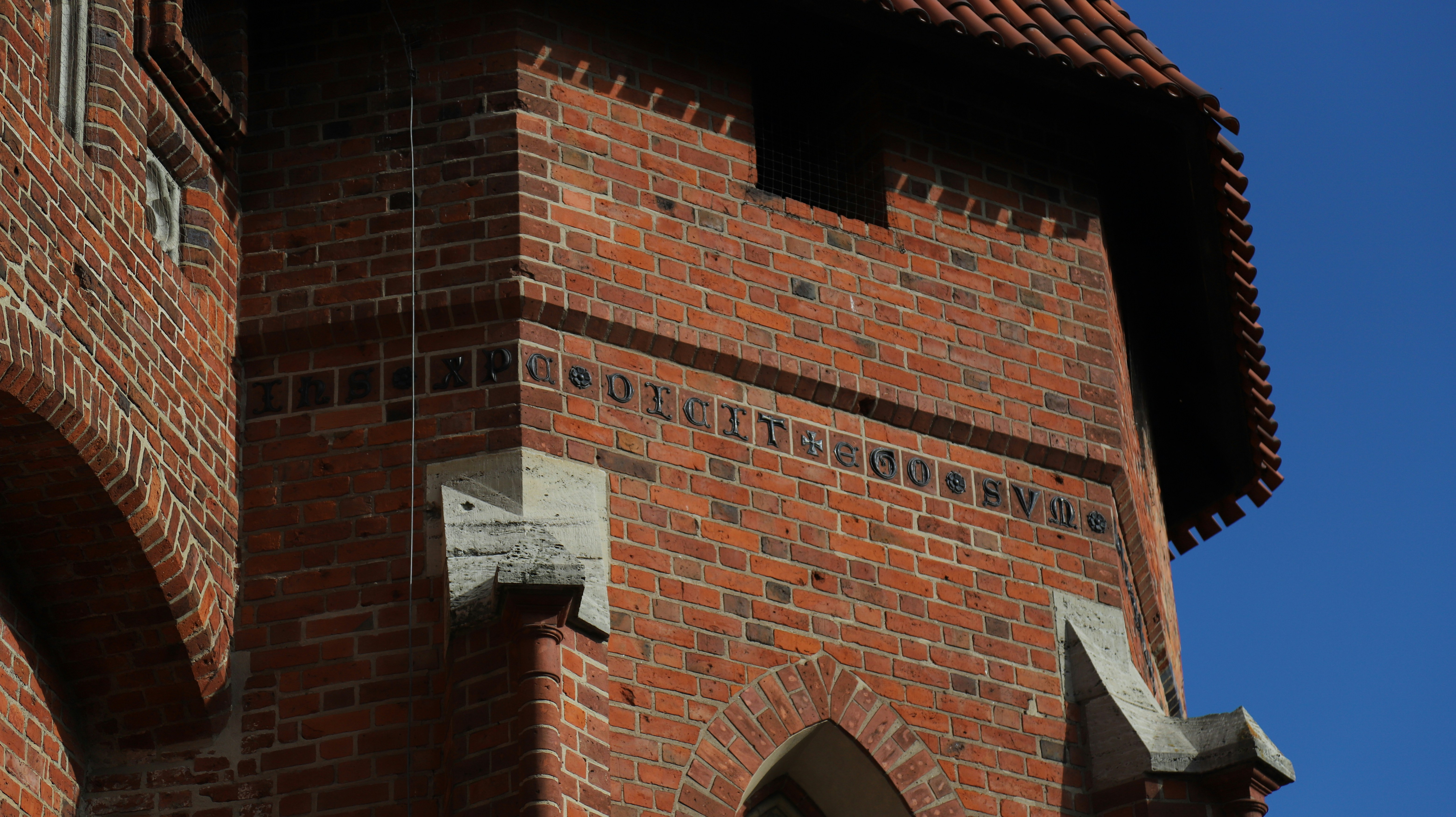Close-up of a red brick castle tower against blue sky