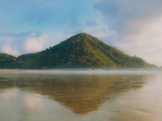 Mountain reflected in wet sand at shoreline