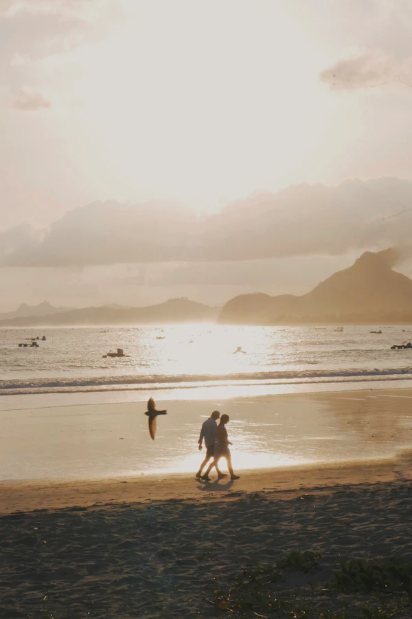 Couple walking hand in hand on a Zanzibar beach at sunset