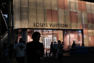Louis vuitton store exterior at night with people.