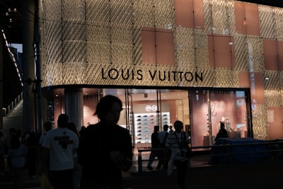 Louis vuitton store exterior at night with people.