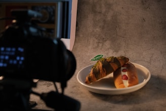 Croissant and pastry on a plate with camera