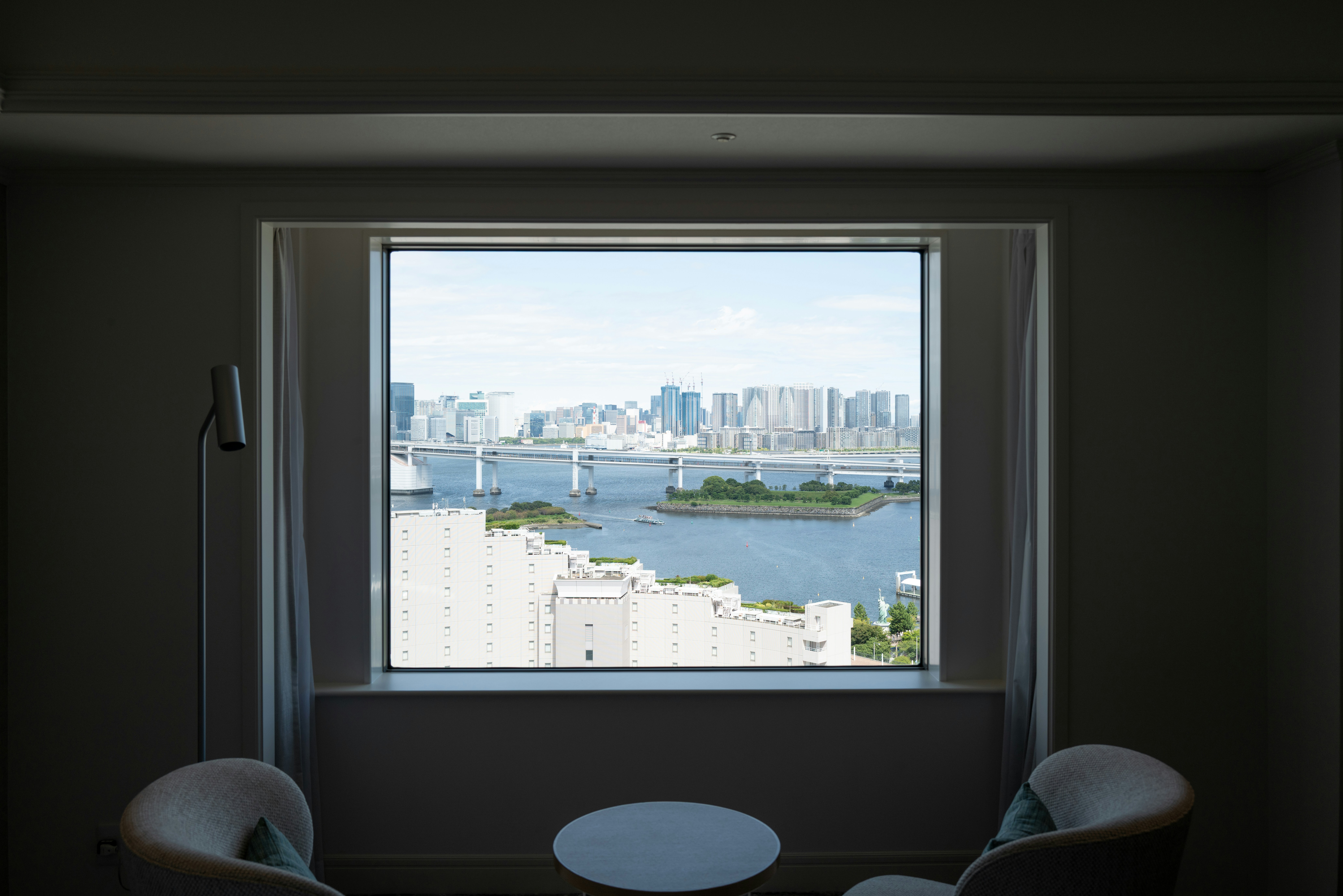 Cityscape view through a large window with chairs.
