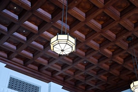 Ornate wooden coffered ceiling with geometric light fixture