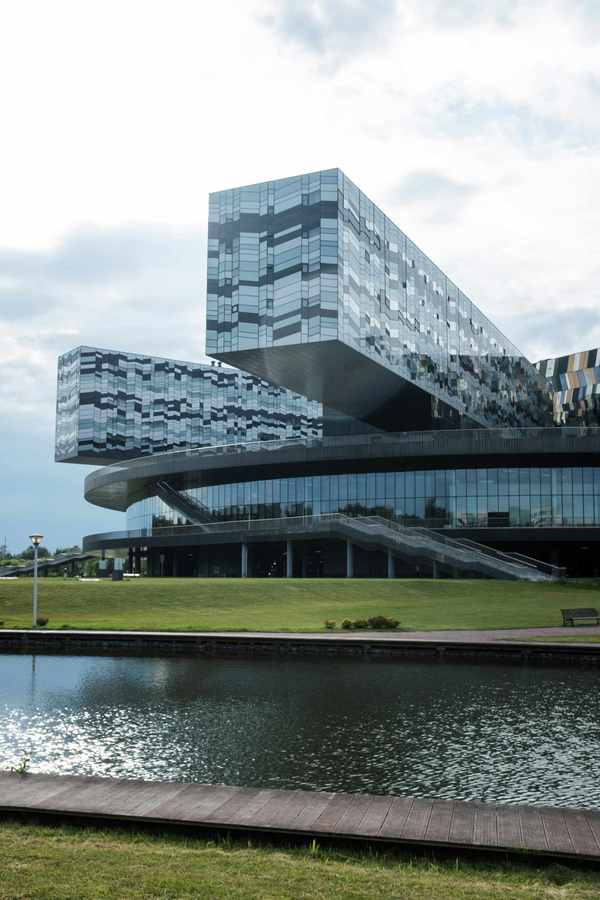 Modern glass building with reflective facade and water