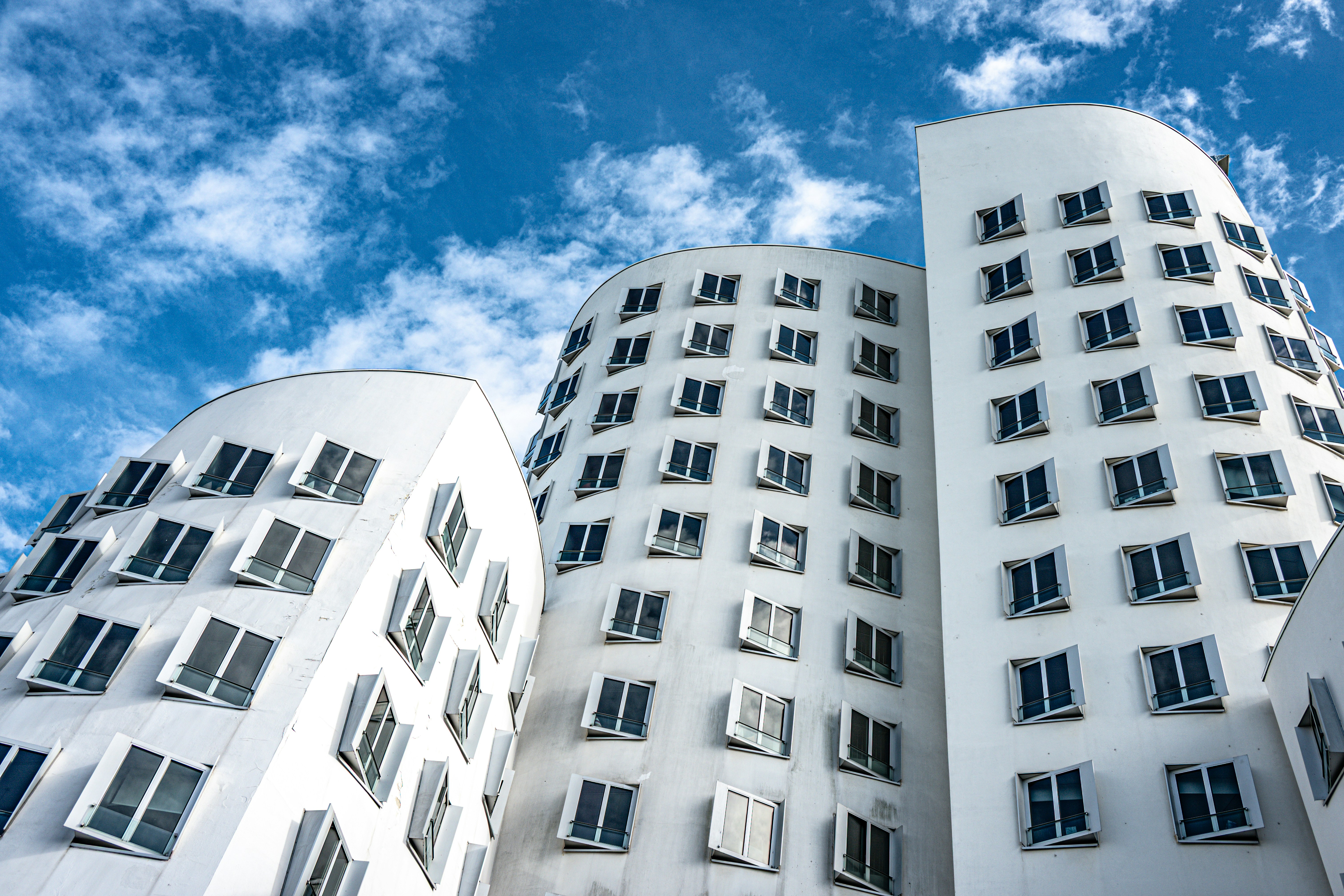 Modern white buildings with many windows against blue sky