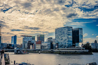 Modern city skyline with glass buildings and river.