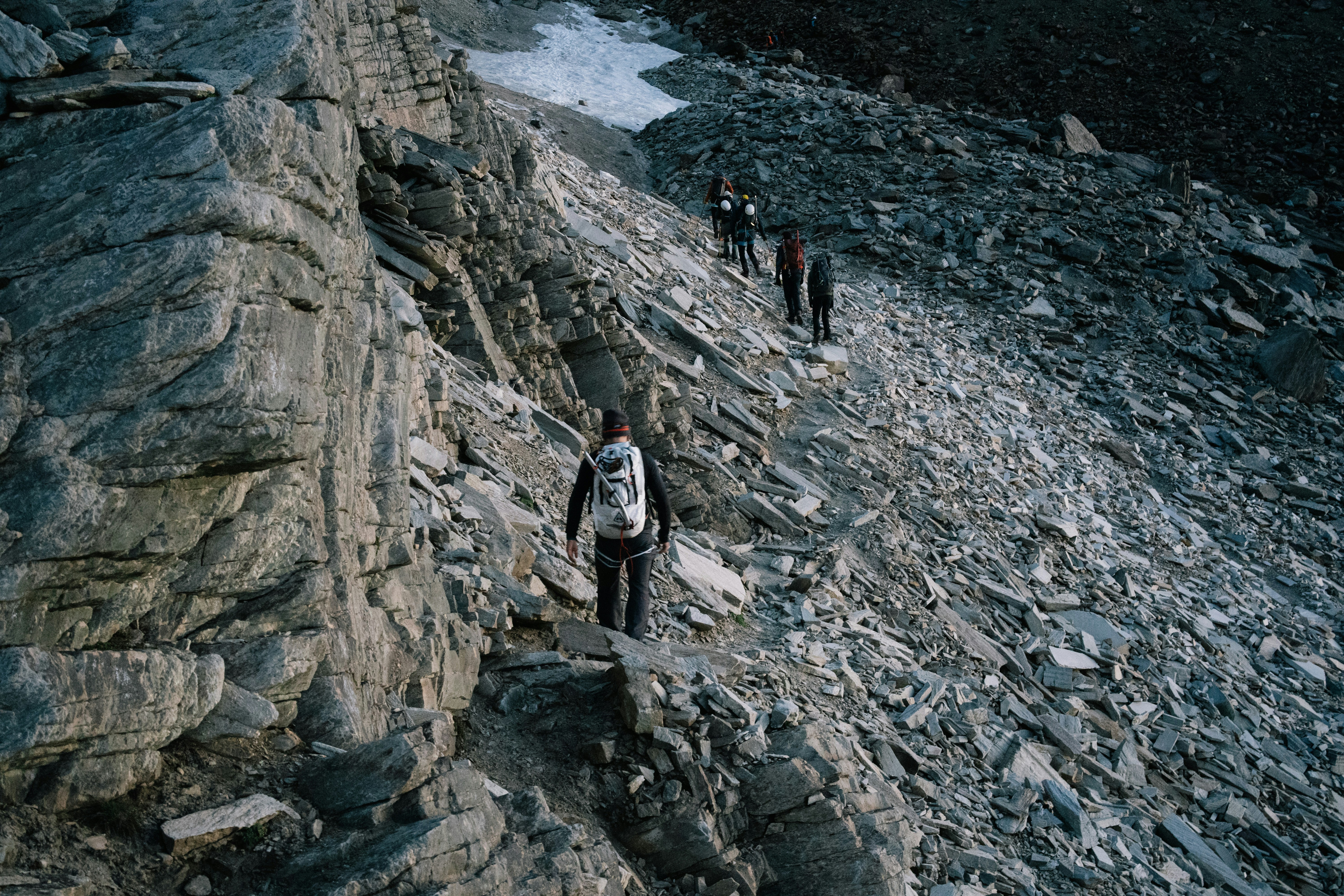 Die Wanderer steigen über einen steilen, felsigen Bergpfad hinauf.