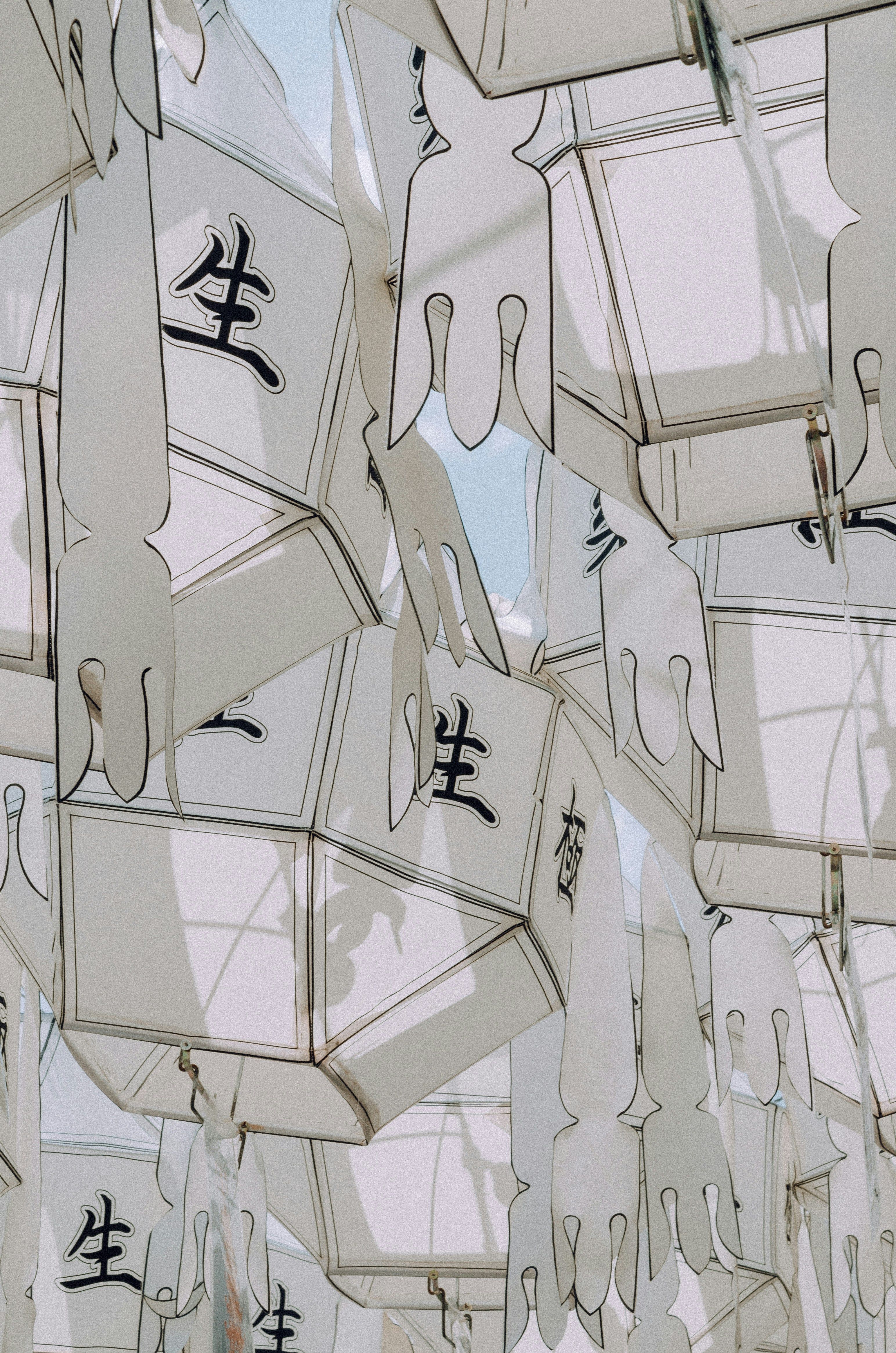 White lanterns with asian characters hang close together.