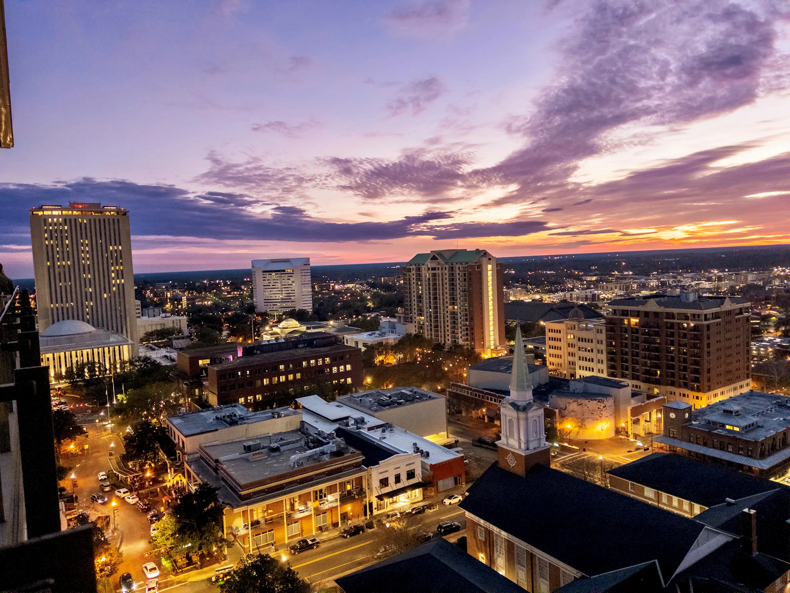 A city skyline at dusk under colourful clouds