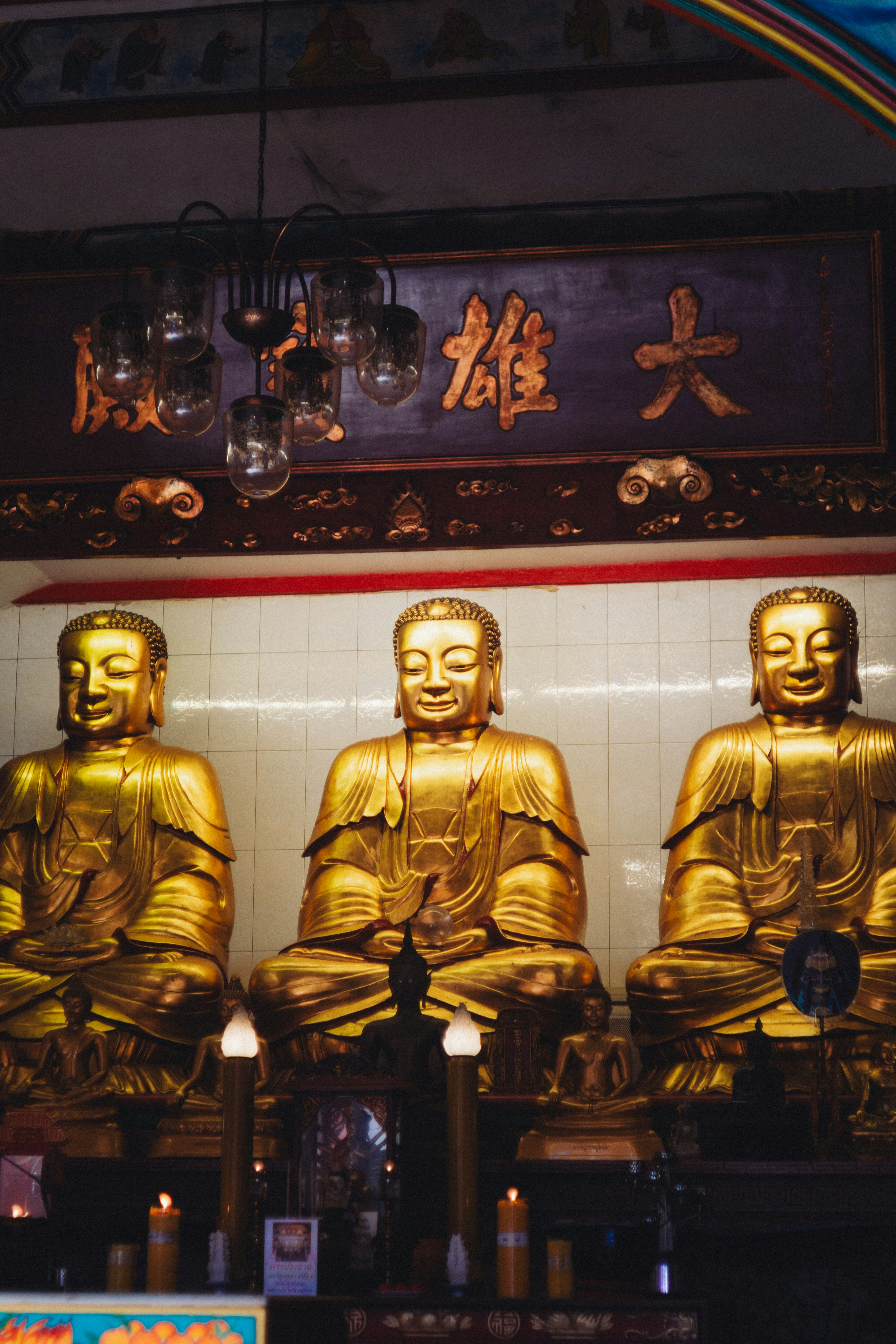 Three golden buddha statues in a temple.