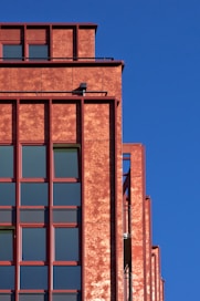 Red building facade against a clear blue sky