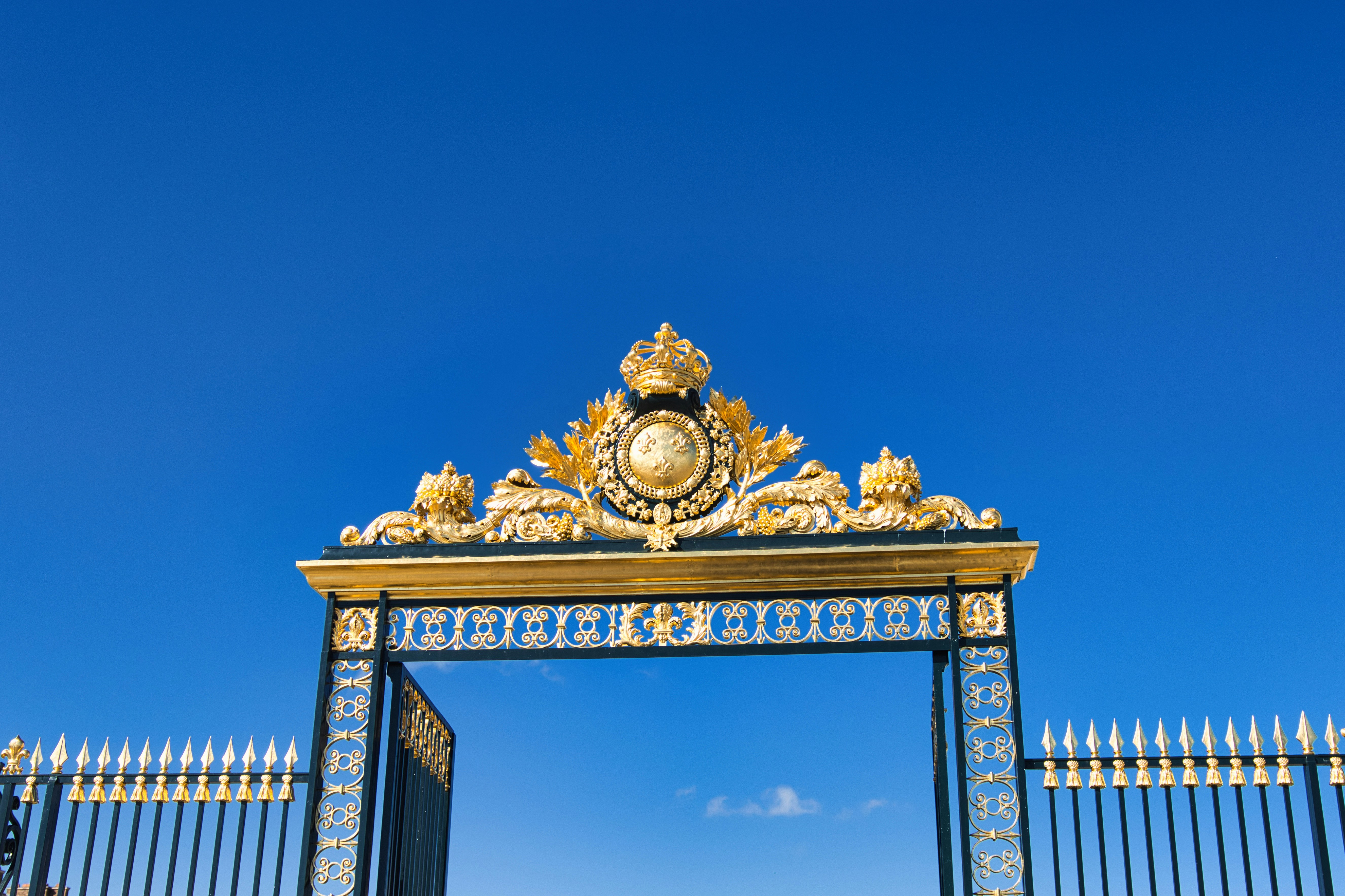 Ornate golden gate against a clear blue sky
