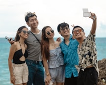 Group of friends taking a selfie by the ocean