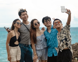 Group of friends taking a selfie by the ocean