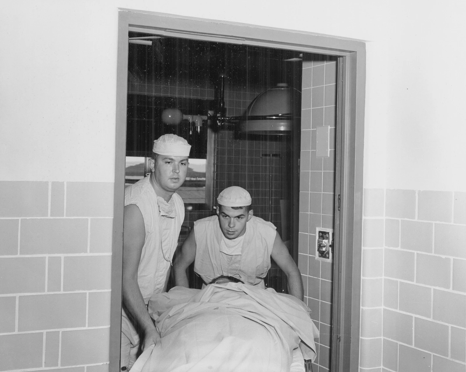 Two medical professionals moving a patient on a trolley