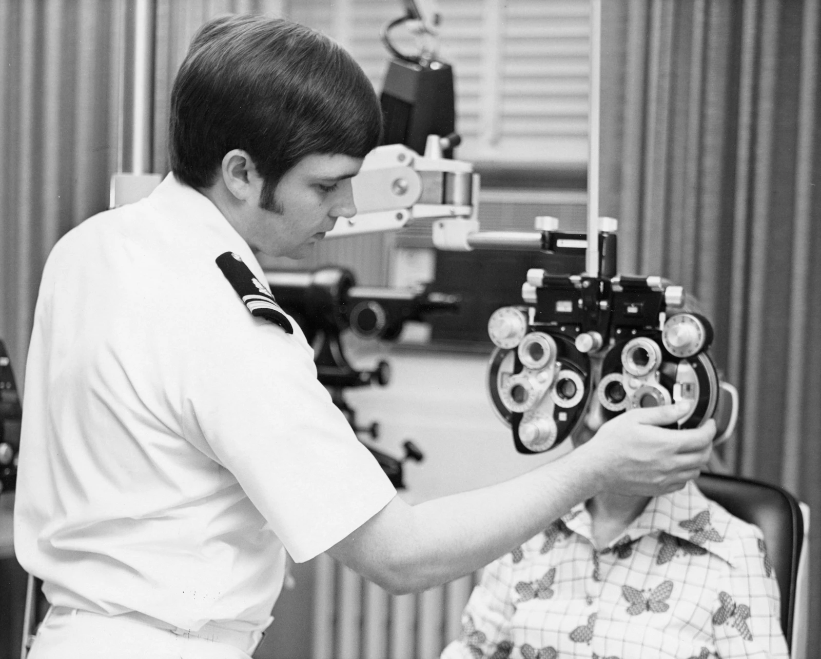 Optometrist examining a patient's eyes with a phoropter at DRISHTI