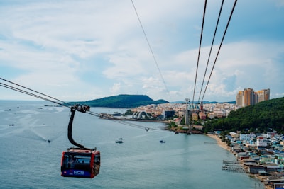 Cable car over the sea with coastal city view
