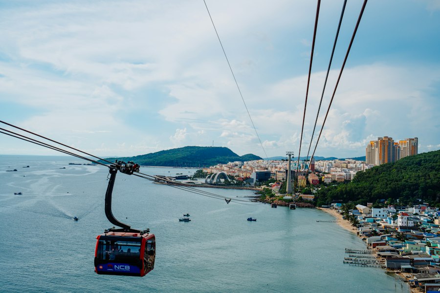 Cable car cabin travelling over the sea towards Hon Thom island, Phu Quoc, with the coastal town behind