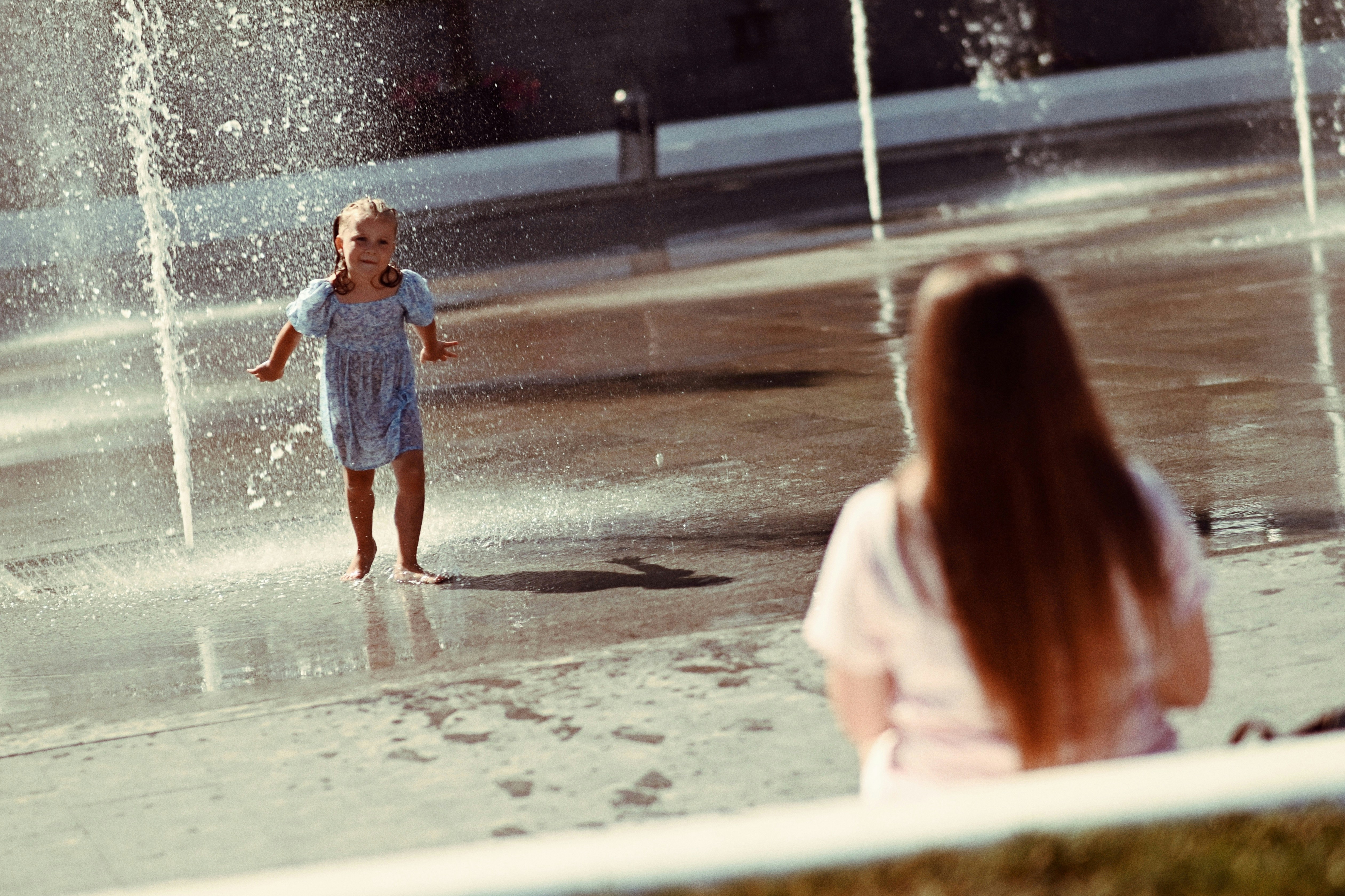 Child splashing in water fountain